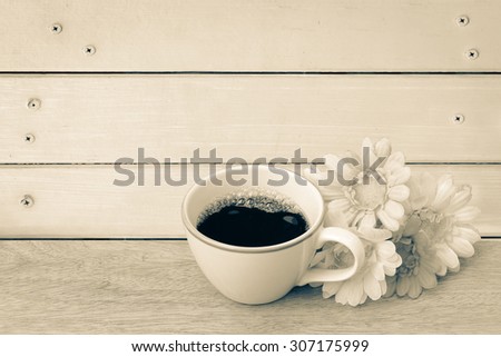 black coffee and bunch of flower on wooden wall and nails background ,vintage tone