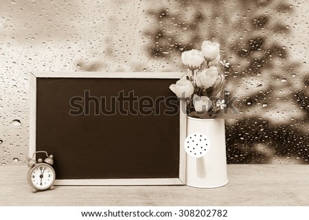 blackboard and watering pot vase with blur drop on mirror with dark tree background  ,vintage tone