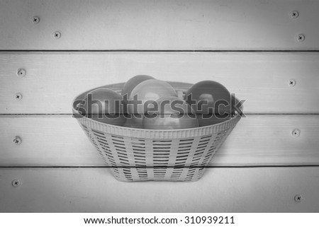color balls in basket with wooden wall and nails background  ,black and white tone