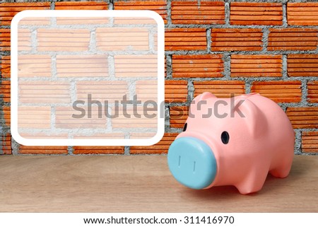 white frame and pink piggy bank on orange brick wall background