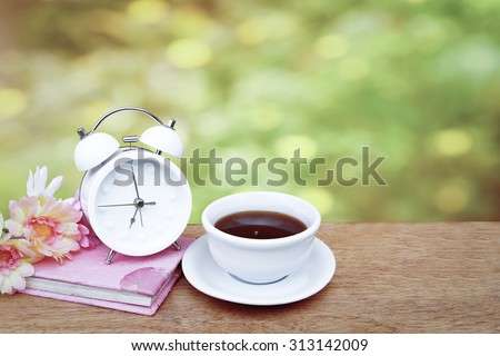 tea and flower on book with blur from yellow flower bush background