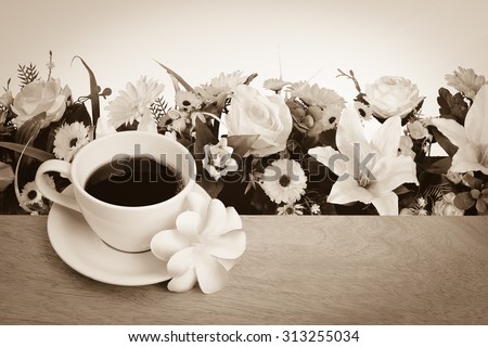 black coffee and purple flower with artificial florist background