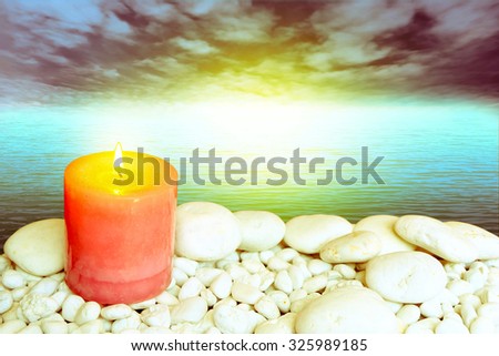 scented candles on white pebble and stone with blur dark ocean and light background ,vintage tone
