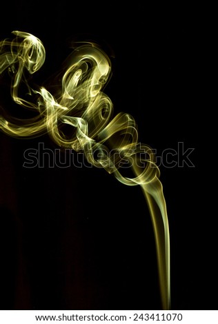 Smoky Abstract pattern, golden yellow smoke against black background.  Taken in vertical format.
