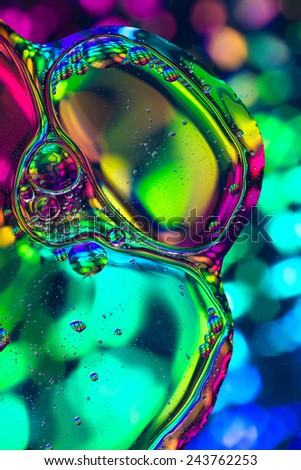 Colorful rainbow colours abstract shot of oil and water mixed together to show interesting bubbles patterns and shapes.  Ideal as vivid bright background, taken in portrait format.
