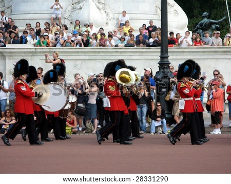 LONDON - AUGUST 11 : Tourists watch the changing of guards at Buckingham Palace  in London, England. This tradition has taken place since 1660.