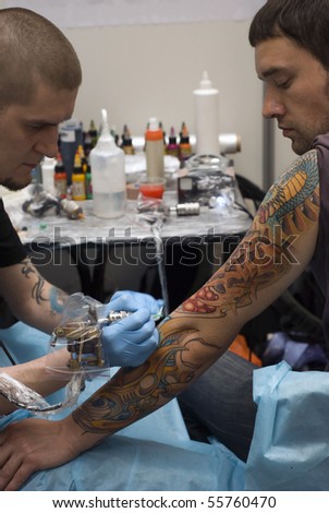 SAINT PETERSBURG - JUNE 20: Tattoo artist at work at St.Petersburg Tattoo Festival - a four-day event on art of tattooing, body modification, body art June 20, 2010 in St. Petersburg, Russia.
