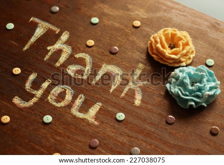 thank you note, flowers and buttons on wooden background