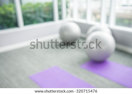 Abstract yoga balls and mat in fitness room background