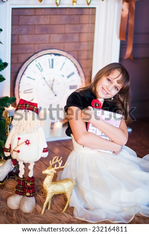 little girl sitting at the decorative fireplace in the Christmas room