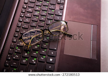Blank business laptop, mouse and glasses
