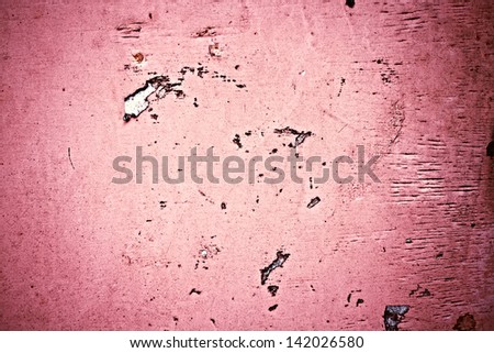 The old concrete pink wall with pink scraps of paper ads