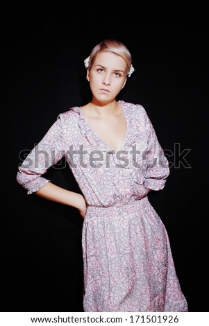Portrait of beautiful young woman in lilac sundress on black background