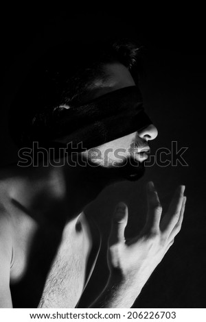 Portrait of nude young men blindfolded on a black background