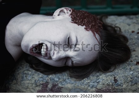 Young woman with a broken head in the blood close up
