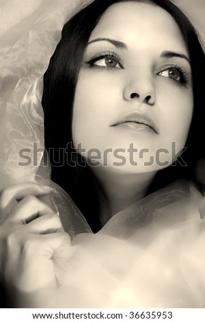 Portrait of the beautifful woman with dark blue eyes in a silk scarf