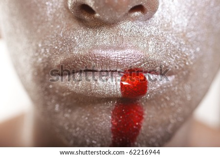 Men\'s lips with bronze makeup and blood close up