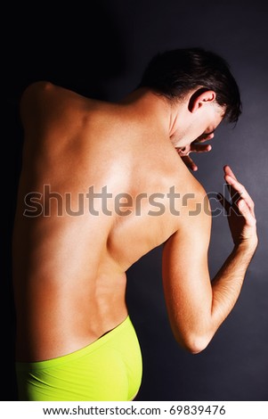 naked tanned young men back on black background