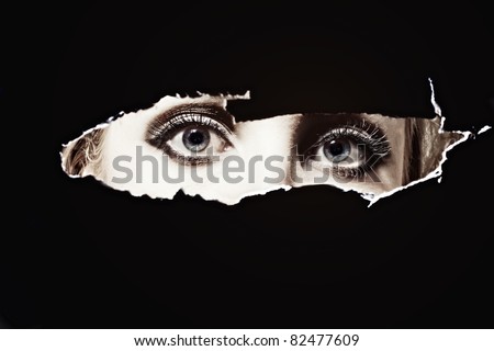 Women\'s blue eyes spying through a hole