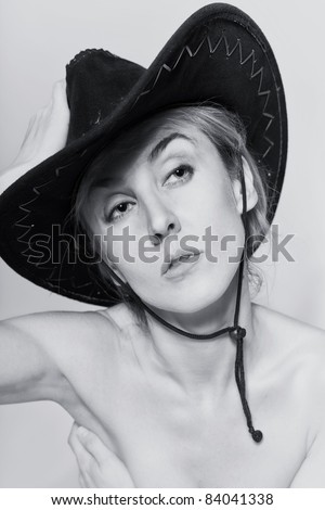 Naked women with cowboy hat on light background