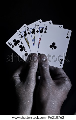 Metal men\'s hands with playing cards on a black background
