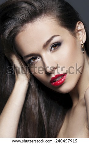 Model with chic lips make-up with red lips and long healthy brown hair