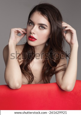 Young woman with beautiful healthy face with red lipstick and red manicure.Beautiful young woman with clean skin of the face.