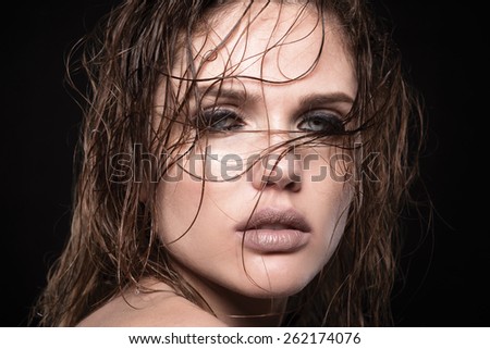 Beautiful young model with long wet hair, dark makeup, fresh summer look with damp beach hairstyle