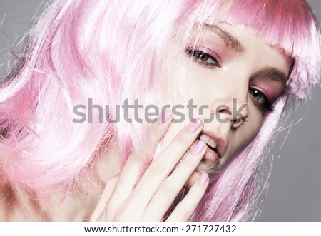 Beautiful young model with bright manicure,pink wig,hairdressing,hand at the person