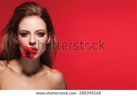 Beautiful woman with evening make-up and salon hairdo . Smoky eyes. Complicated hairstyle for party,isolated in red background