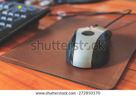 computer mouse on a wooden table, selective focus, process color with vintage tone.
