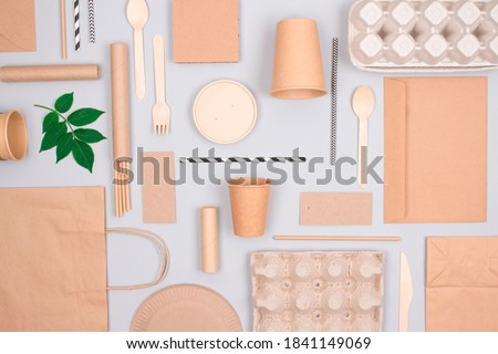 Flat lay composition with eco-friendly tableware - kraft paper food packaging on light grey background. Street food paper packaging - cups, plates, straws, containers and paper bags. Mockup