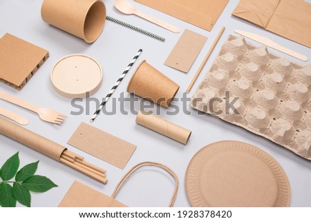 Flat lay composition, set of eco-friendly tableware and kraft paper food packaging on light gray background. Street food paper packaging - cups, plates, straws, containers and paper bags. Mockup
