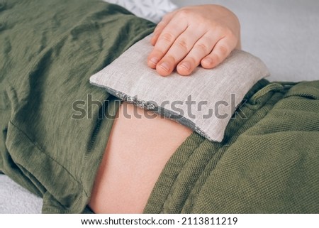 Boy using cherry pits heating pad. Cherry stone thermal pillows, cherry pit filled pillow. Alternative medicine and therapy, pit sack for spa massage, chiropractic care. Selective focus 商業照片 © 