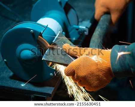 Similar – Image, Stock Photo Worker sharpening axe with electric grinder
