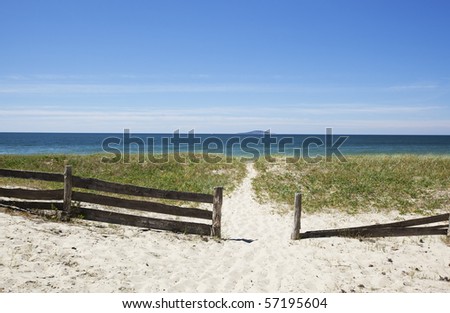 Path leading through a gate to the ocean beach on Byrum, Sweden. Island on the horizon.