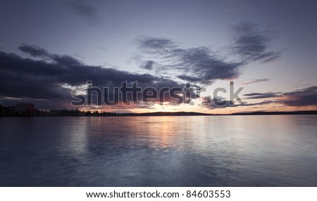 Sun goes down over a Swedish lake, bad weather on the horizon