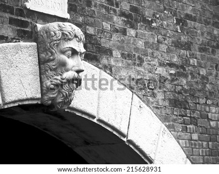 Old gargoyle (old man face) in a wall in Venice