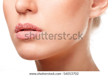 Beautiful young woman\'s face fragment. Lips with a transparent crystals. Isolated on white