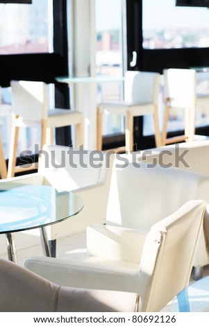 White cafe interior without people. Interior illuminated by bright sunlights.