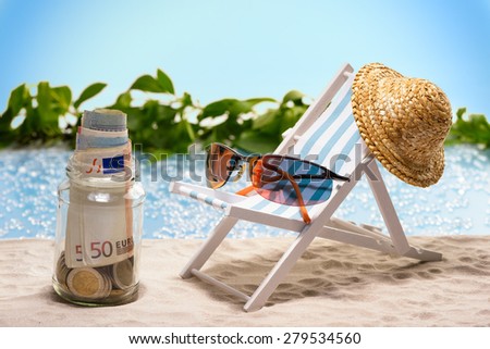 Savings for vacation, glas with money bills and coins at the beach