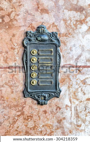 Old wrought iron door bell sign - without labels on marble stone for background purpose.