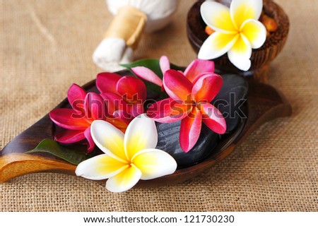 Wellness spa & aromatherapy concept with frangipani flower on jute fabric