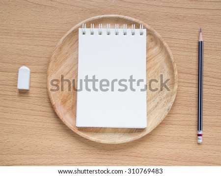 Paper note on wood dish with pencil and eraser, Concept for Menu Creation or Restaurant Commentator.