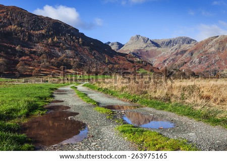 Through the puddles to the pikes. In this lovely view a few puddles lie in the path towards the magnificent Langdale Pikes.