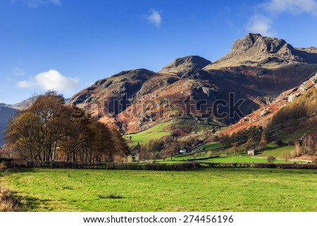 Blues skies over the Langdale Pikes. On a sunny Autumn day the imposing Langdale Pikes stand proudly below a blue sky.
