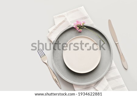empty grey plates on a table with fork and knife. spring menu concept. trendy nordic minimal style tableware. restaurant menu mock up. top view, copy space. scandinavian tableware design.