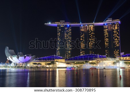 Singapore, Singapore - May 18, 2015: Marina Bay Sands hotel at night with light and laser show in Singapore. The luxury resort is a landmark in Singapore. The laser show starts every evening.