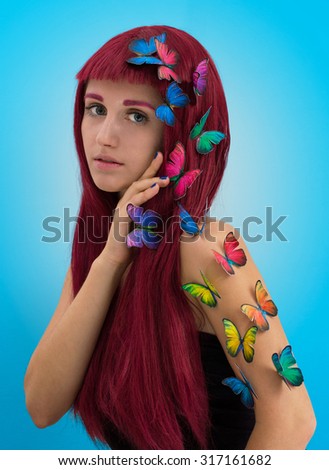 Beautiful young woman with lollipop; red haired woman in cap on light background