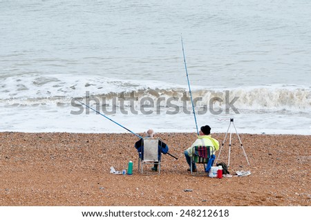Two old men on a beach fishing - a relaxing way to pass the time in retirement; Kent, England.